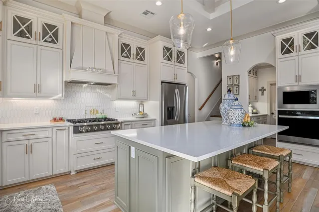 a kitchen with cabinets and wooden floor