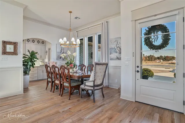 a dining room with furniture potted plants and wooden floor