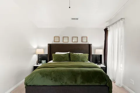 a bedroom with a bed couch and a window