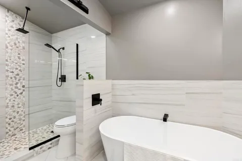 a white bath tub sitting in a bathroom next to a shower