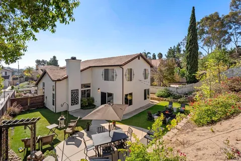 a view of a house with backyard sitting area and garden