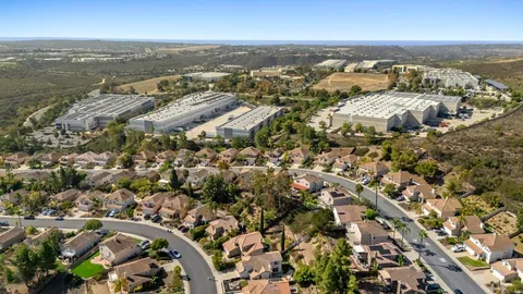 an aerial view of residential houses with outdoor space and trees