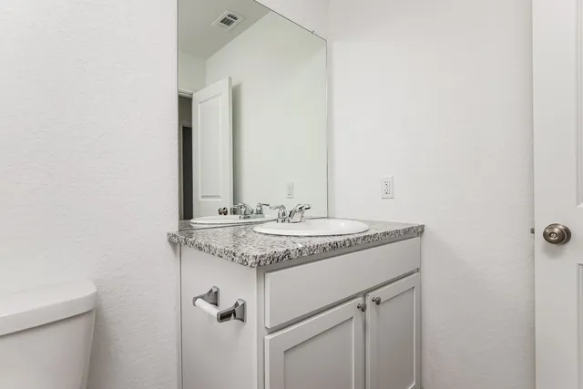 a bathroom with a granite countertop sink and a mirror