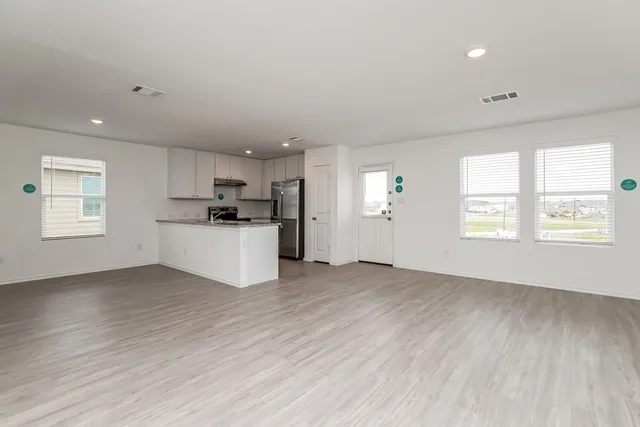 a view of a kitchen with wooden floor and electronic appliances