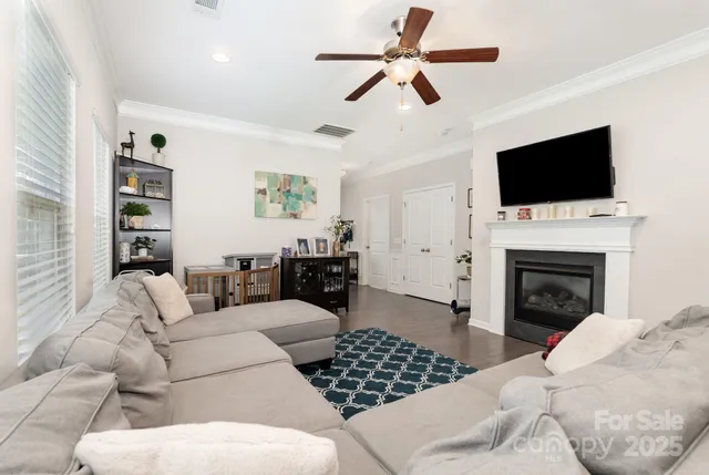 a living room with furniture a flat screen tv and a fireplace