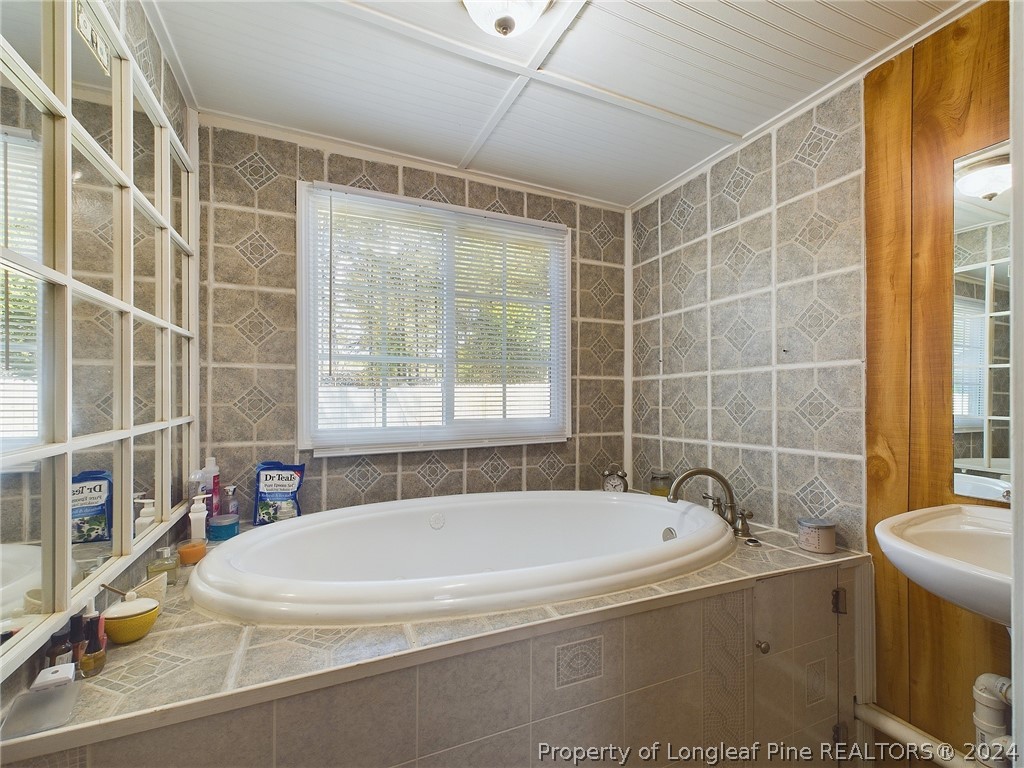 6948 Rockfish Road Raeford, NC 28376 - Photo 19 of 39 a white bath tub sitting next to a shower