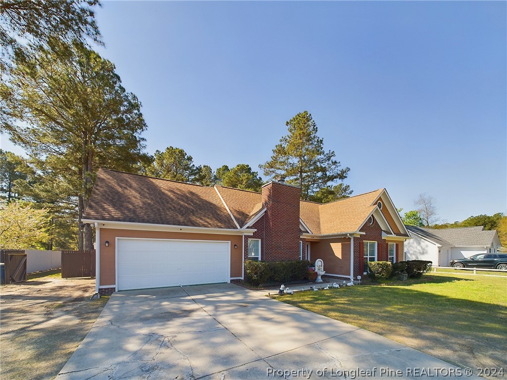 6948 Rockfish Road Raeford, NC 28376 - Photo 2 of 39 a front view of a house with a yard and garage