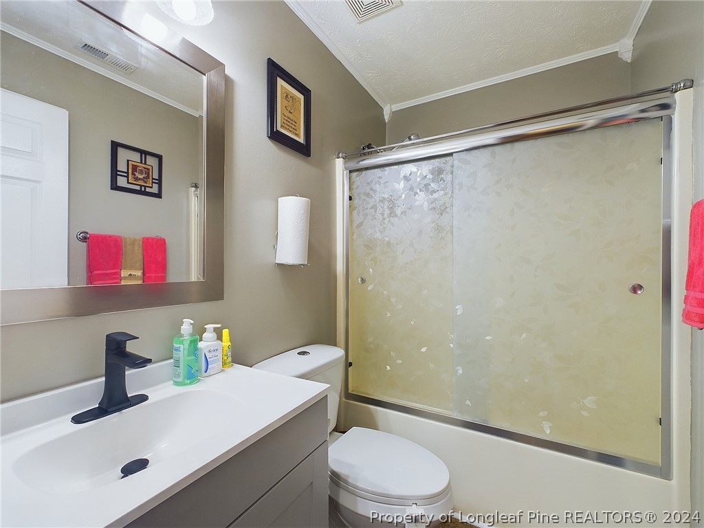 6948 Rockfish Road Raeford, NC 28376 - Photo 27 of 39 a bathroom with a sink mirror vanity and toilet