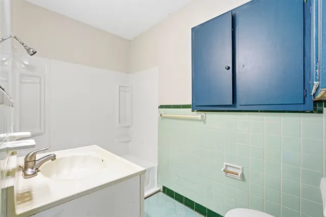 a bathroom with a sink a toilet and a mirror