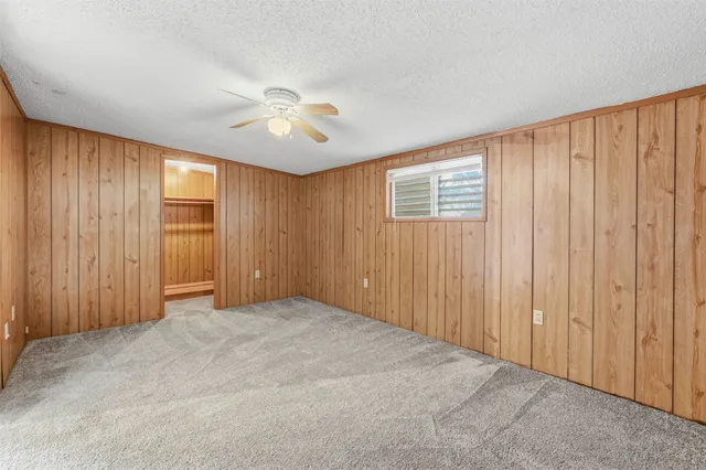 an empty room with windows & cabinet area