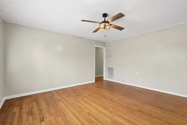 a view of room with wooden floor and ceiling fan