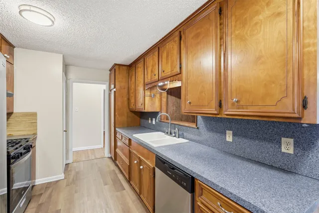 a kitchen with stainless steel appliances granite countertop a sink a stove and a refrigerator