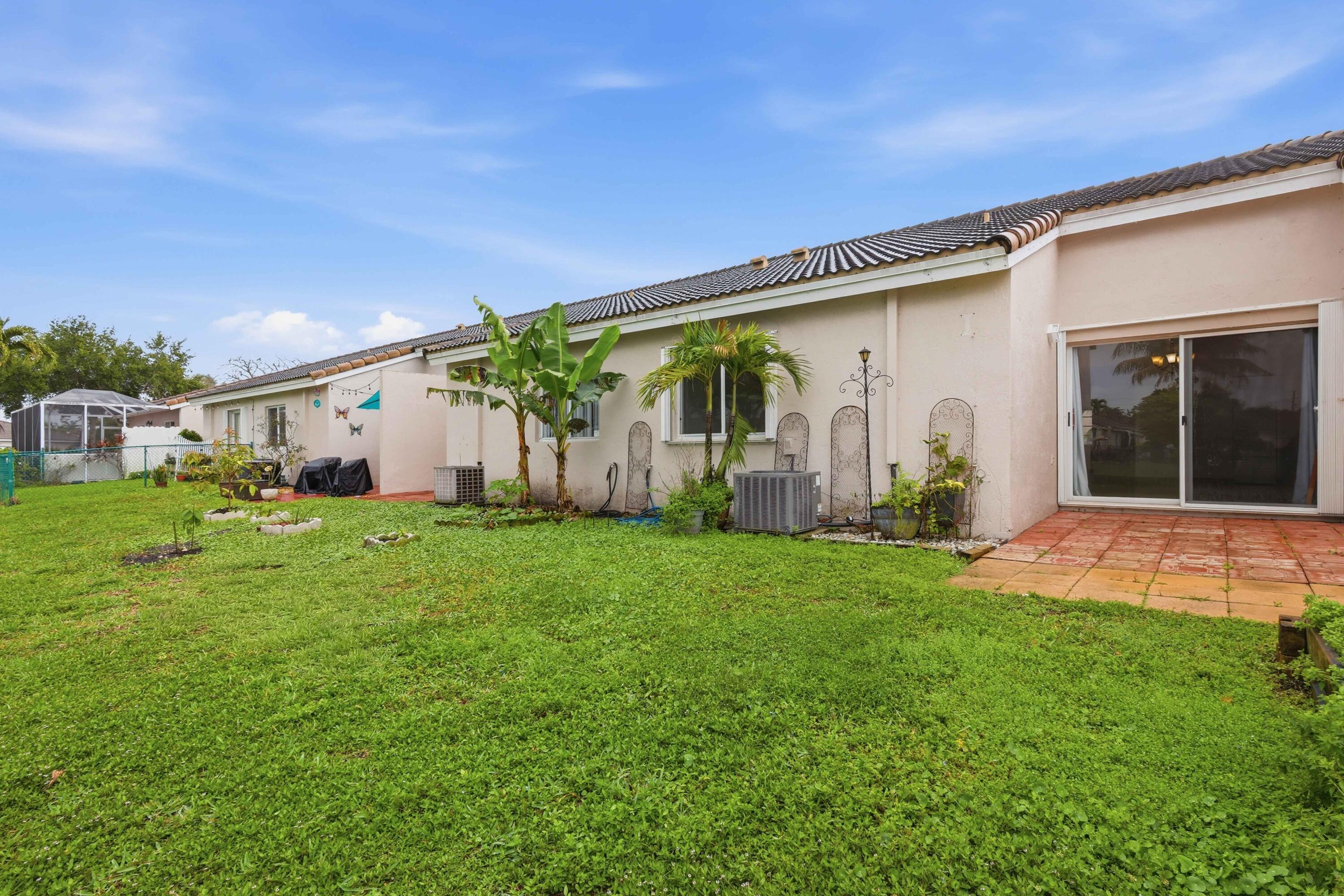 11697 Southwest 19th Street Miramar, FL 33025 - Photo 44 of 48 a backyard of a house with table and chairs