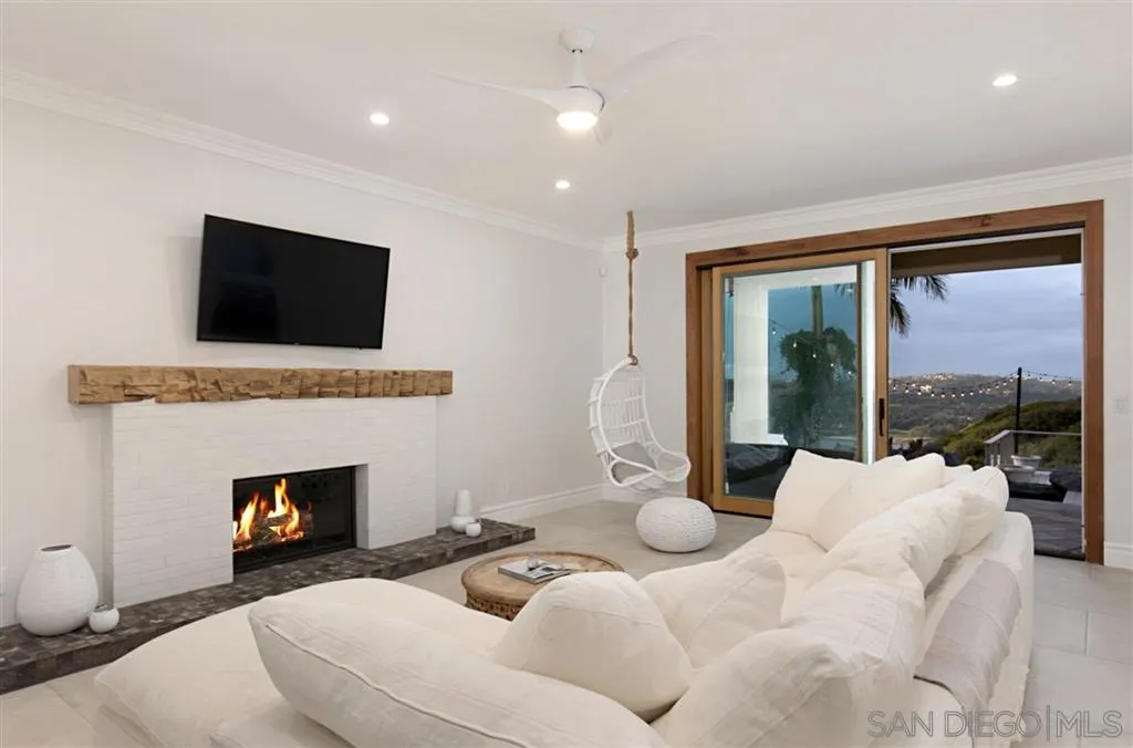 1836 Hawk View Drive Encinitas, CA 92024 - Photo 13 of 25 a living room with furniture fireplace and a flat screen tv