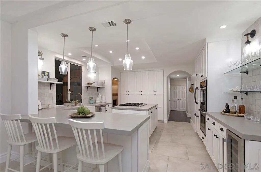 1836 Hawk View Drive Encinitas, CA 92024 - Photo 10 of 25 a kitchen with stainless steel appliances kitchen island granite countertop a sink refrigerator and cabinets