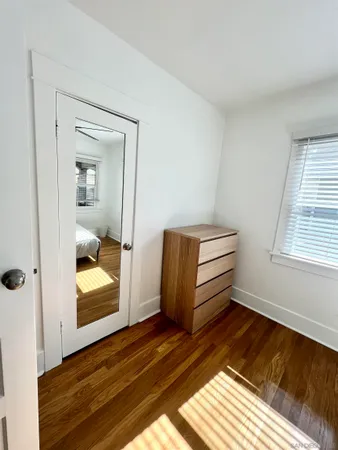 a view of a room with wooden floor and mirror