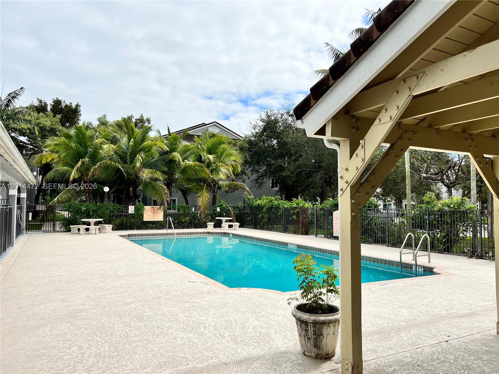 15410 Southwest 284th Street, Unit 8102 Homestead, FL 33033 - Photo 12 of 18 a view of a patio with a table and chairs under an umbrella
