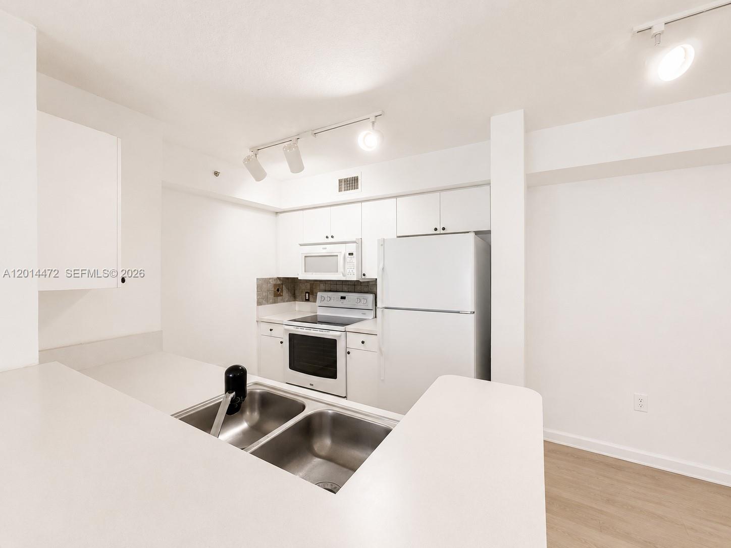 15410 Southwest 284th Street, Unit 8102 Homestead, FL 33033 - Photo 4 of 18 a kitchen with white cabinets and white appliances