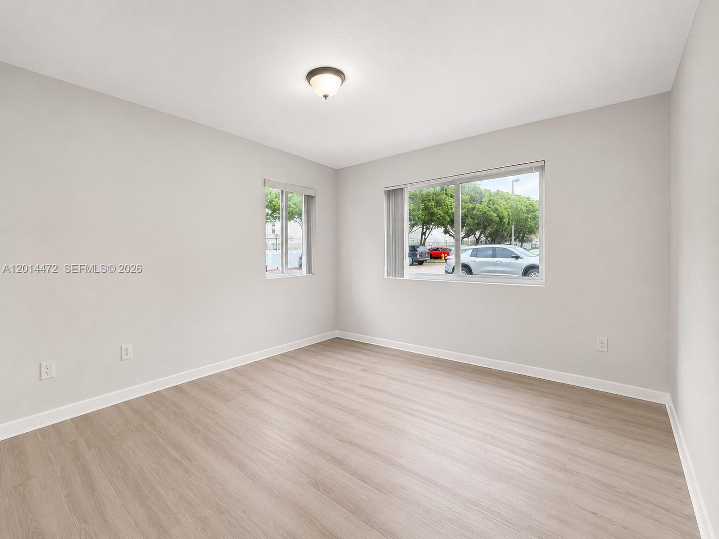 15410 Southwest 284th Street, Unit 8102 Homestead, FL 33033 - Photo 6 of 18 an empty room with wooden floor and window
