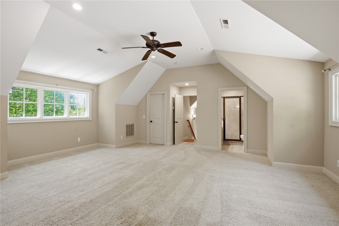 130 River Ridge Road Sunset, SC 29685 - Photo 21 of 47 This spacious, carpeted room offers ample living space with sloped ceilings and abundant natural light from multiple windows.
