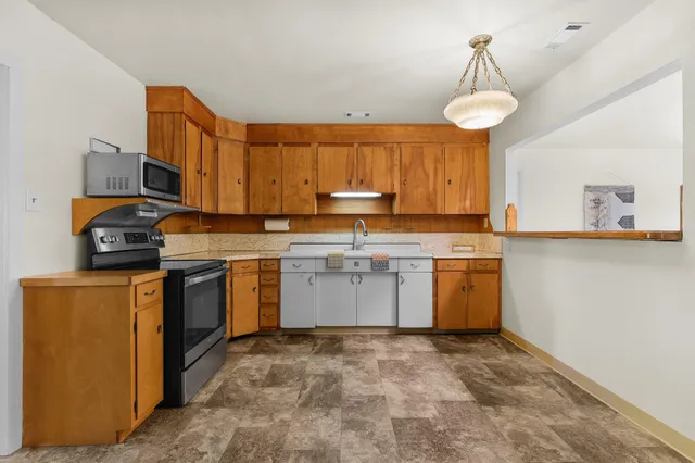 a kitchen with a sink window and cabinets