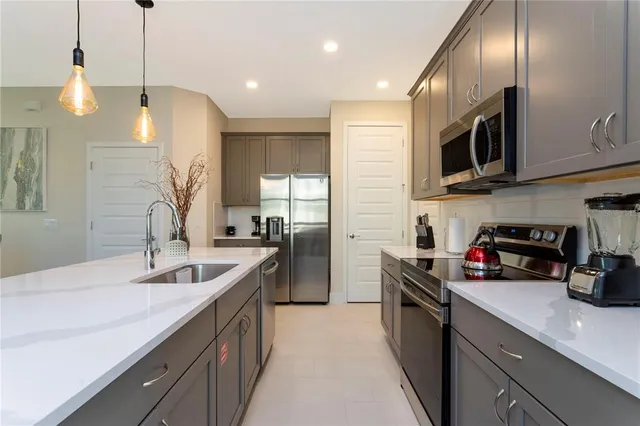 a kitchen with stainless steel appliances granite countertop a sink a stove and a refrigerator