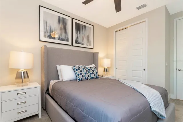 a bedroom with a bed and a lamp on the dresser