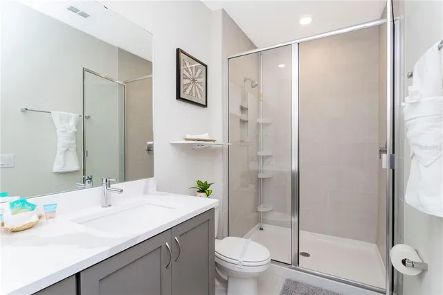 a bathroom with a granite countertop sink toilet and shower