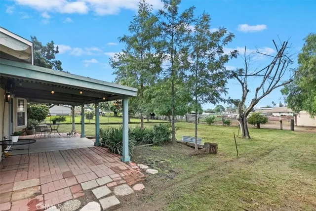 a view of a patio with table and chairs and potted plants with wooden fence