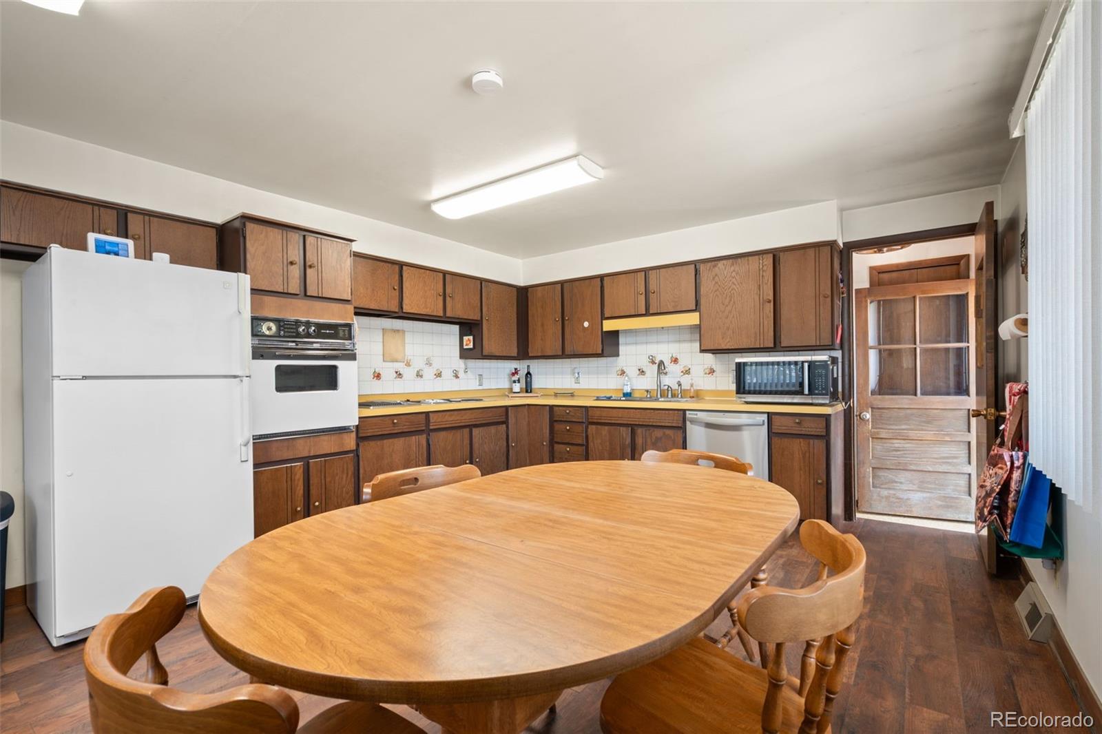 5410 Indiana Street Golden, CO 80403 - Photo 12 of 50 a kitchen with white cabinets and stainless steel appliances