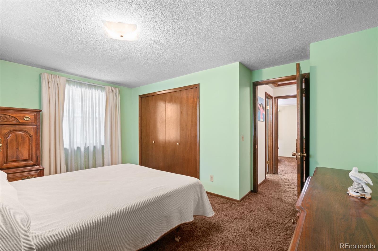 5410 Indiana Street Golden, CO 80403 - Photo 17 of 50 a bedroom with a bed and a refrigerator