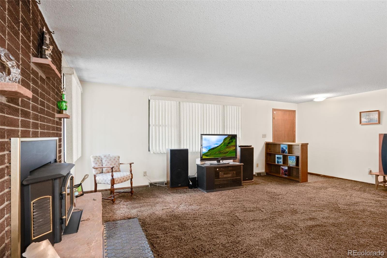 5410 Indiana Street Golden, CO 80403 - Photo 7 of 50 a living room with furniture a fireplace and a flat screen tv
