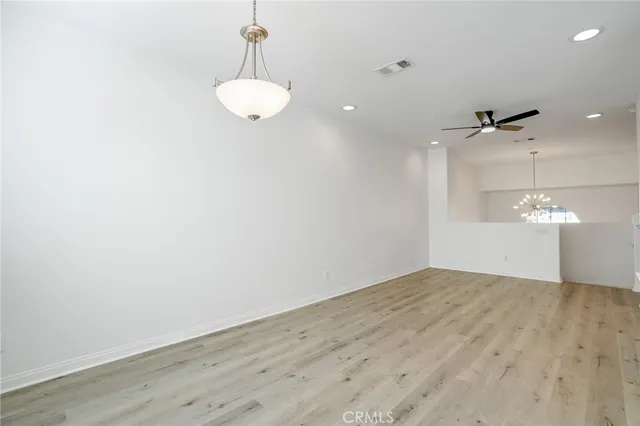 a view of a room with wooden floor and ceiling fan