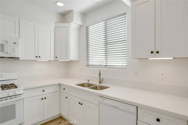 a kitchen with white cabinets and a window