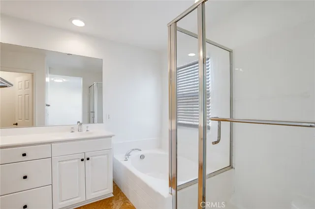a bathroom with a tub sink and mirror