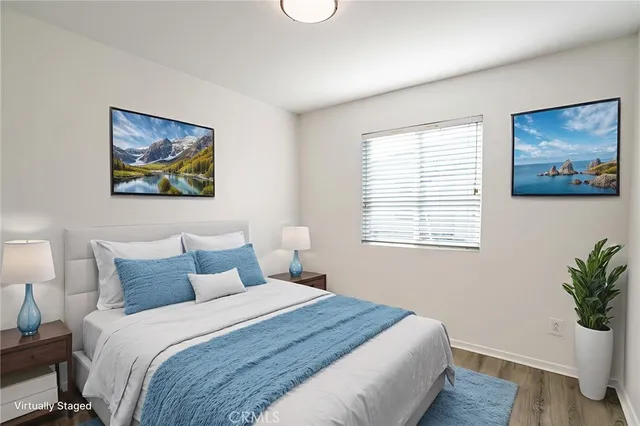 a bedroom with a large bed and a potted plant