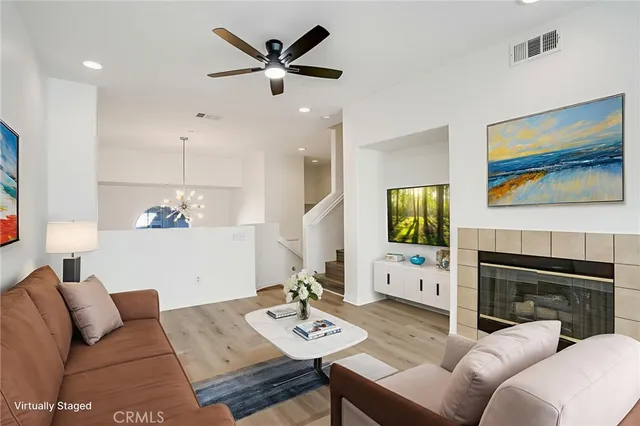 a living room with furniture a flat screen tv and a fireplace
