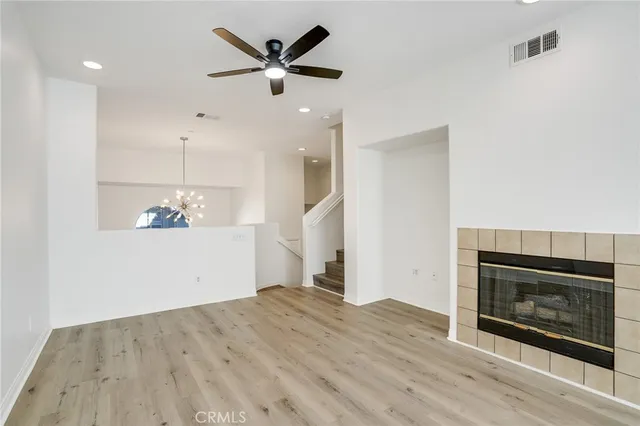 a view of a room with wooden floor and a ceiling fan