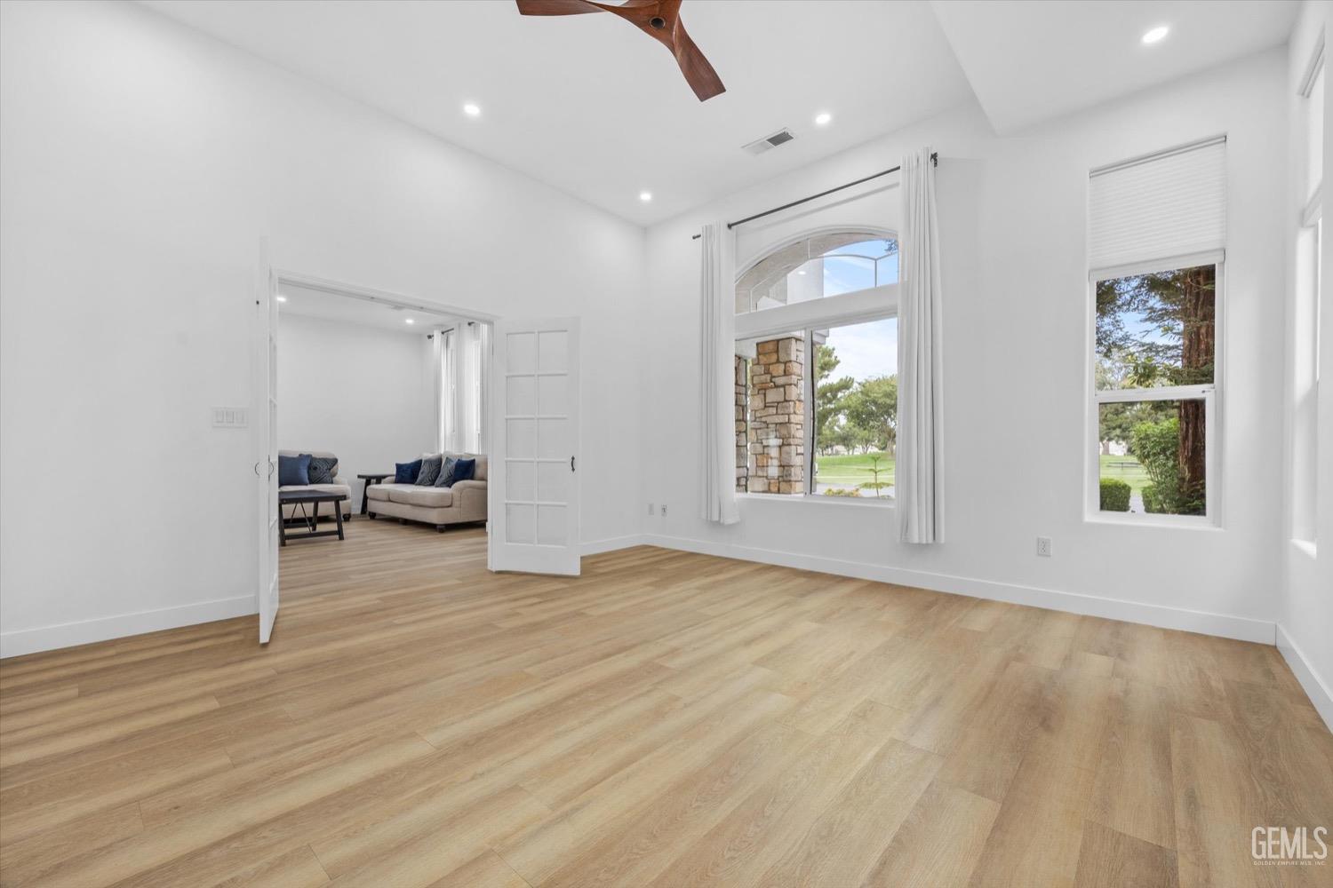 Undisclosed Address Bakersfield, CA 93311 - Photo 19 of 67 a view of an empty room with a window and wooden floor