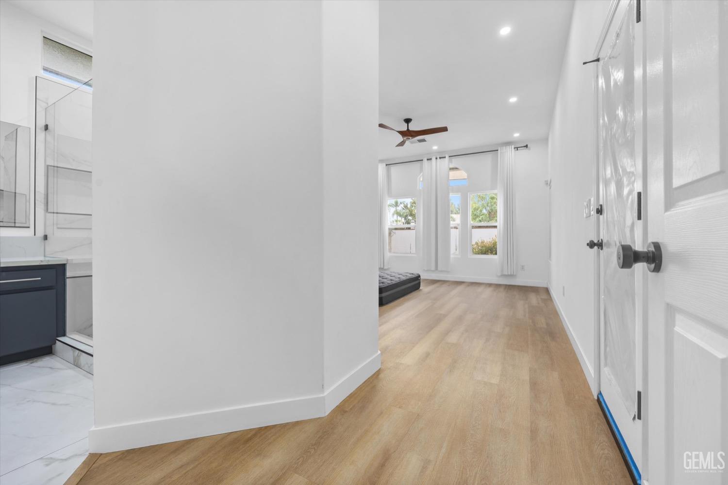 Undisclosed Address Bakersfield, CA 93311 - Photo 35 of 67 a view of a hallway with wooden floor and a bathroom