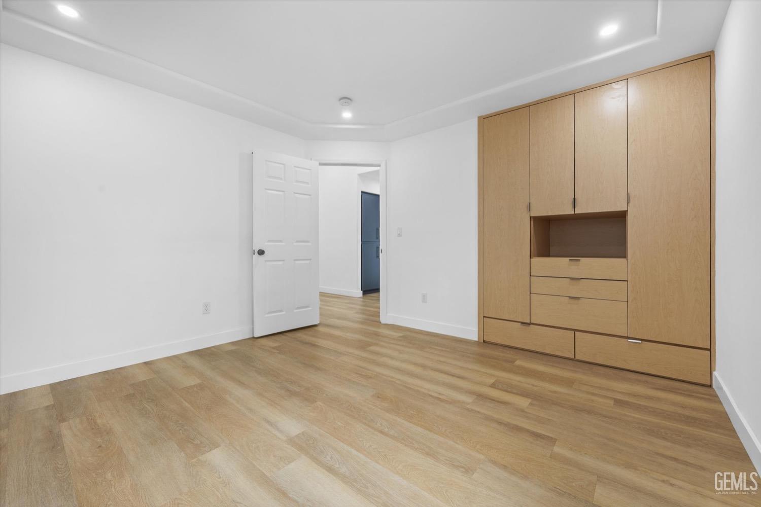 Undisclosed Address Bakersfield, CA 93311 - Photo 54 of 67 a view of an empty room with wooden floor and cabinet