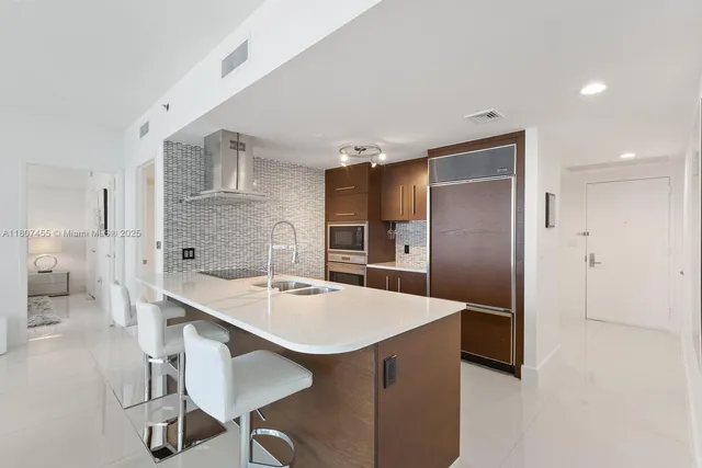 a kitchen with kitchen island a appliances a sink and a refrigerator