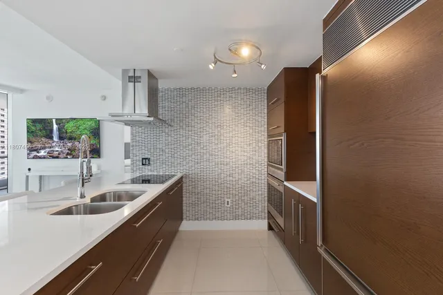 a kitchen with stainless steel appliances granite countertop a sink and a refrigerator