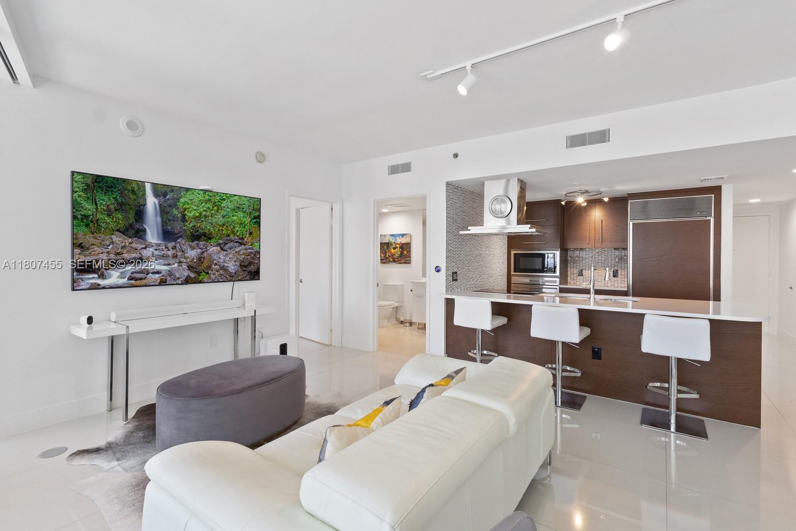 495 Brickell Avenue, Unit 2304 Miami, FL 33131 - Photo 6 of 29 a living room with furniture and a flat screen tv