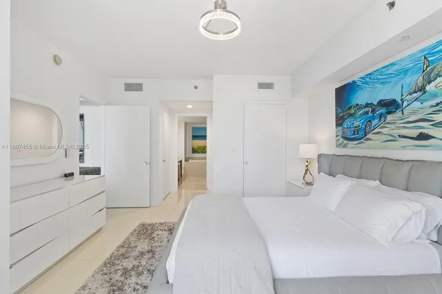 a bedroom with a bed and a painting on the wall