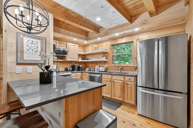 a kitchen with stainless steel appliances granite countertop a sink a stove and a refrigerator