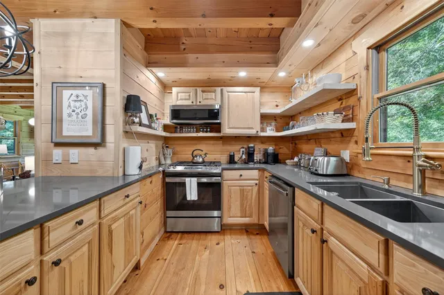 a kitchen with stainless steel appliances granite countertop a stove a sink and a dining table with granite countertops