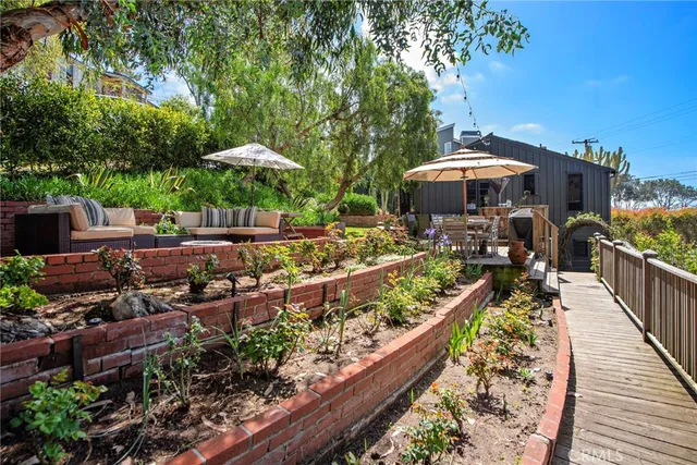 a view of a patio with furniture and a garden
