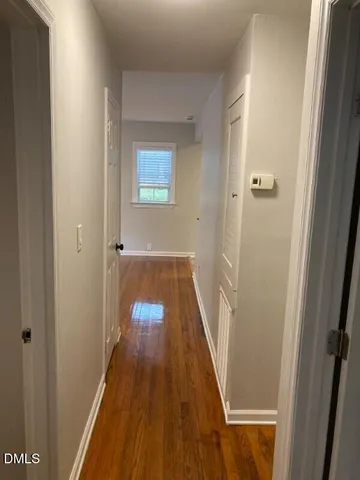 a view of a hallway with wooden floor