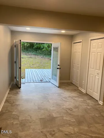 an empty room with a bed and large window